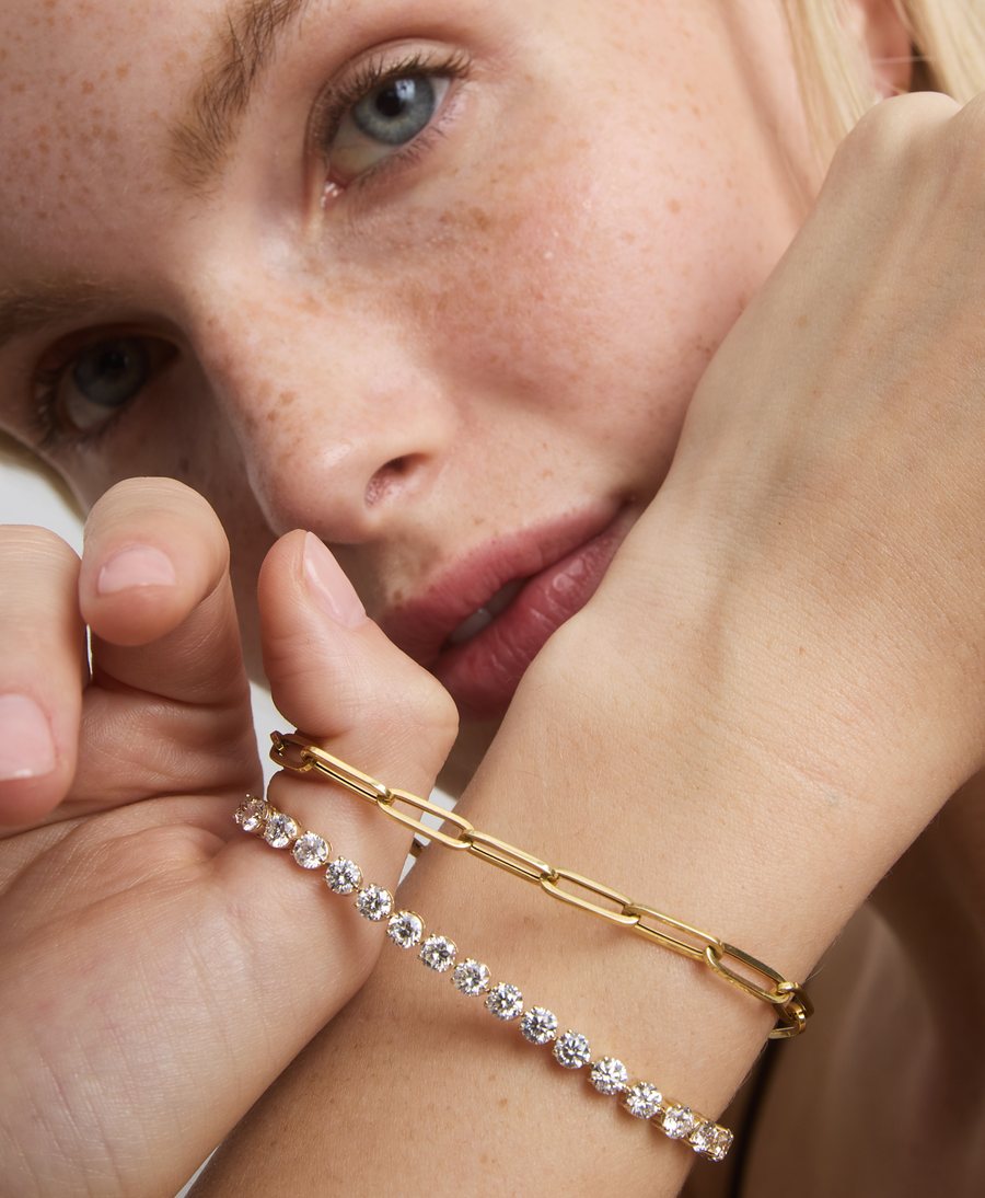 Model with diamond tennis and paperclip-chain bracelets