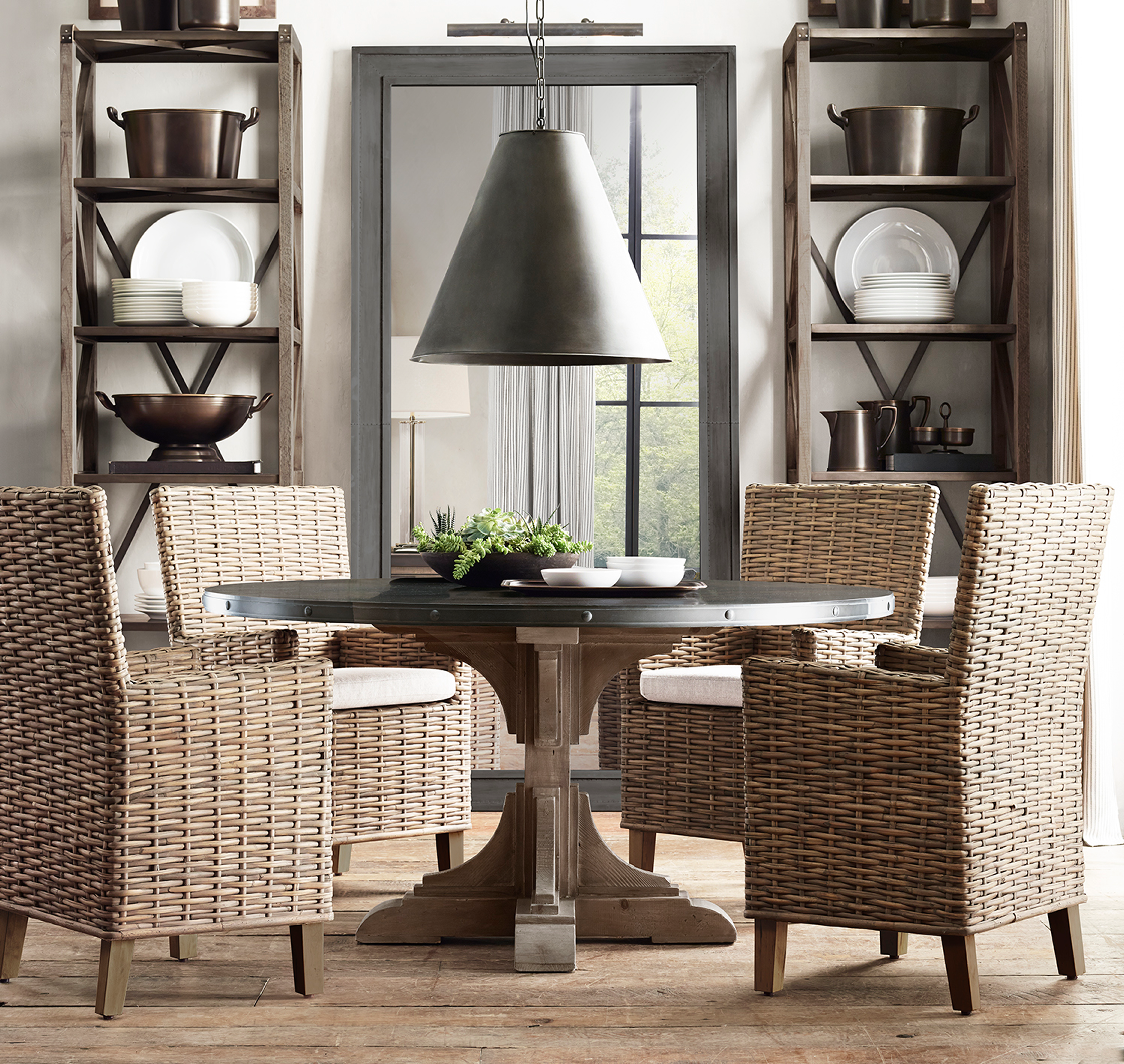 Round pedestal dining table, wicker chairs, iron mirror, cone pendant