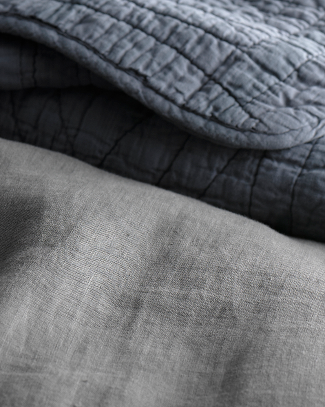 Garment-dyed linen duvet in navy, folded over charcoal linen