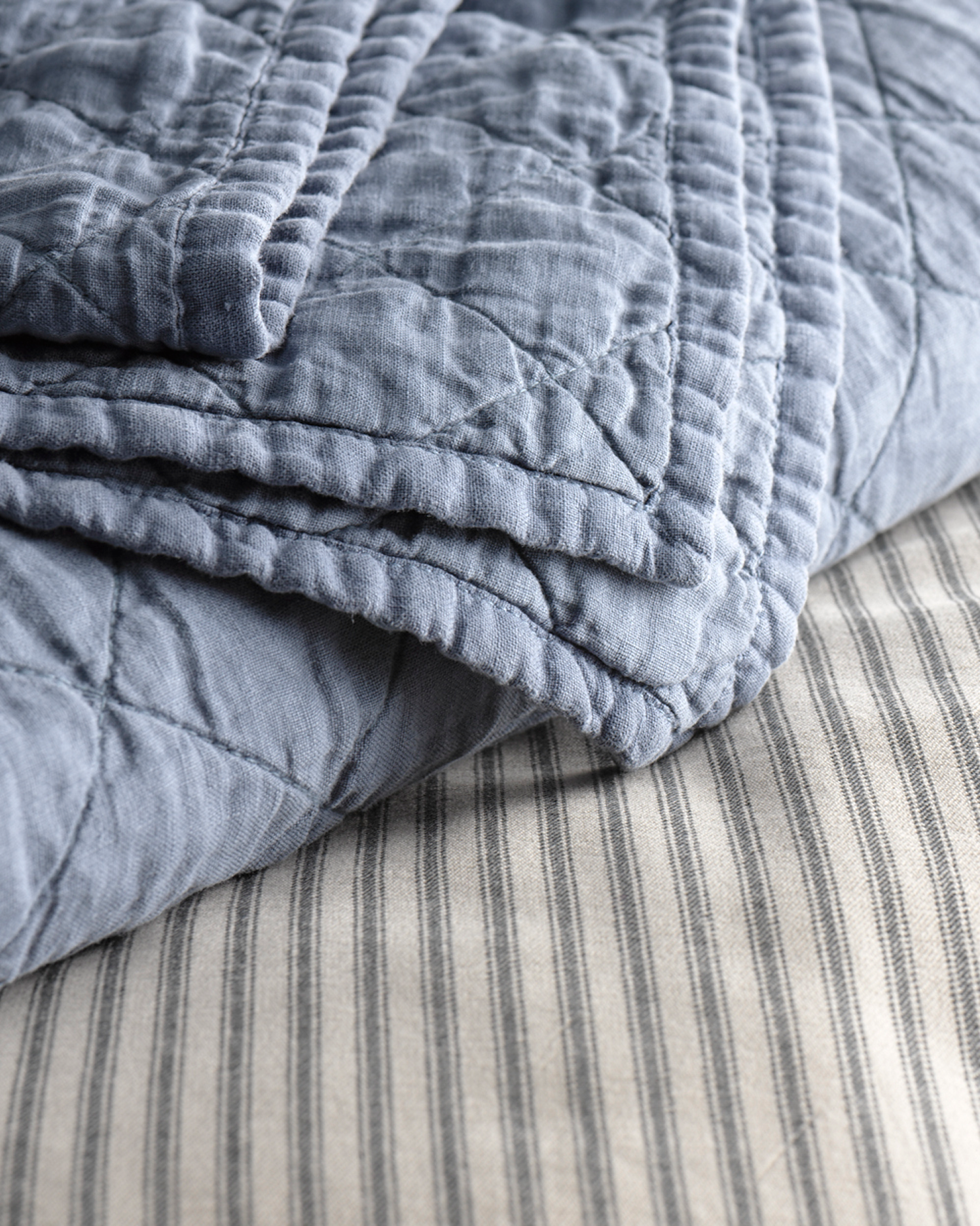 Ticking-stripe duvet in blue, draped over striped percale sheets