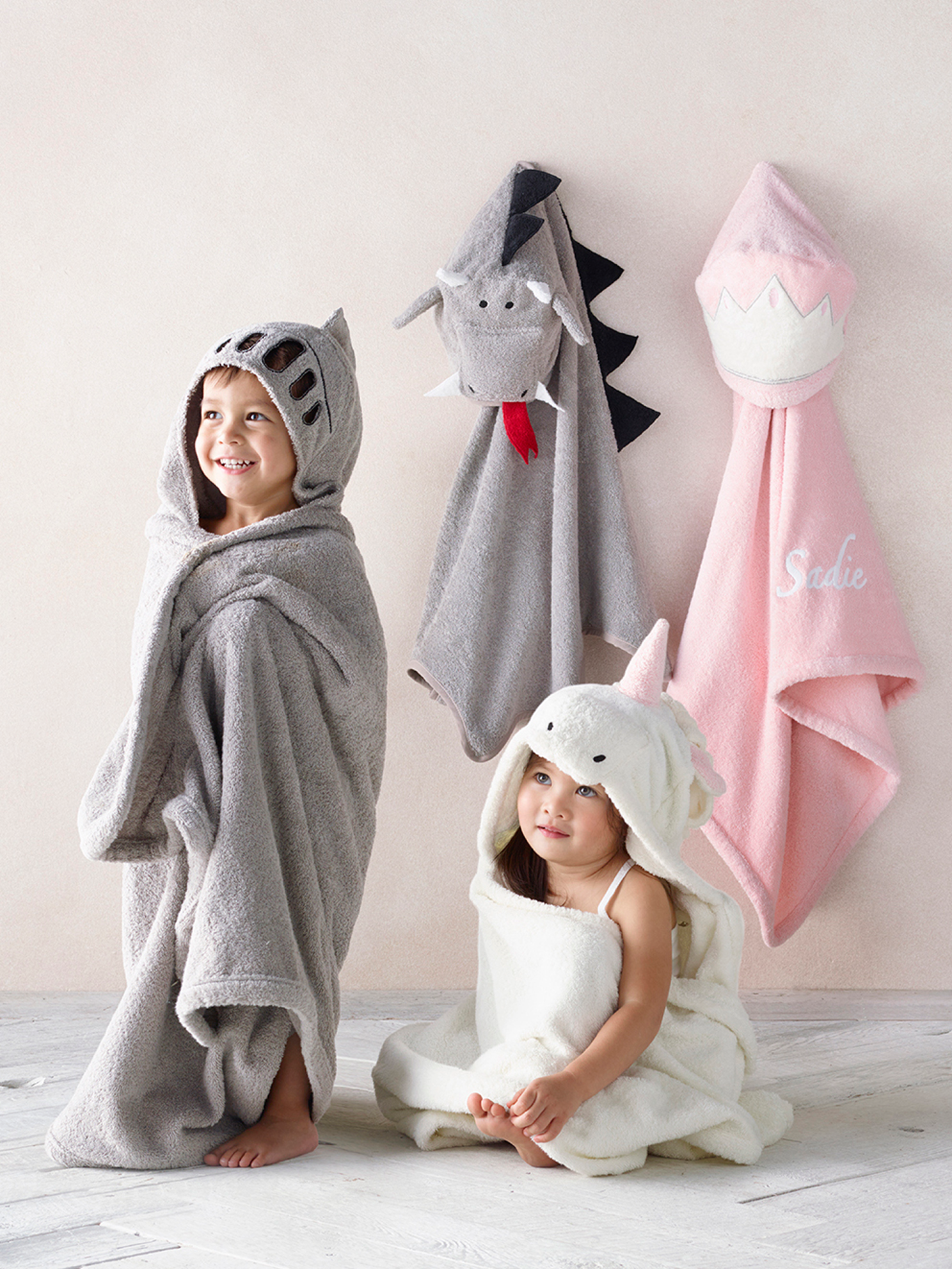 Hooded animal-face bath towels (dragon, shark, unicorn) with a child wrapped in one