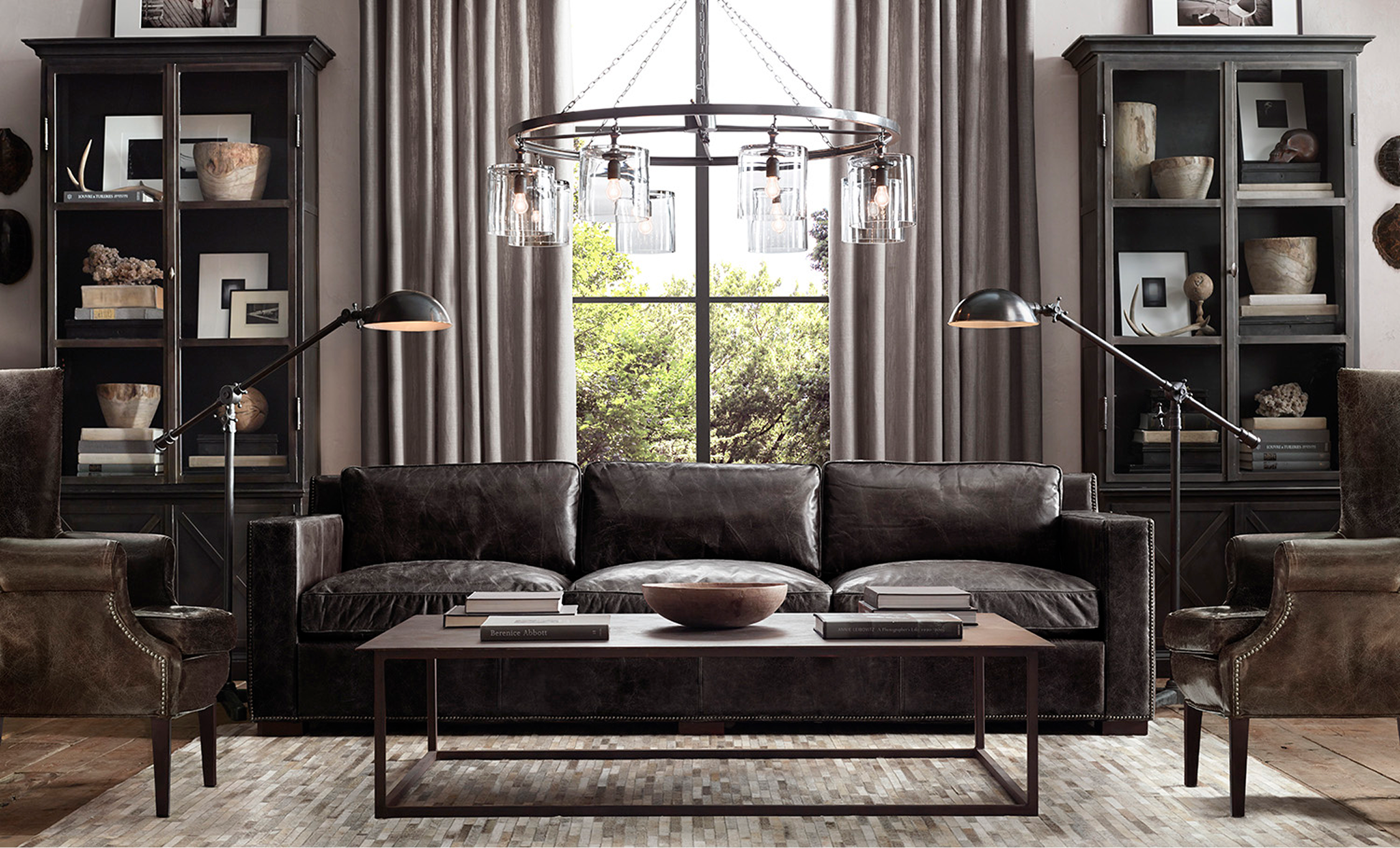 Dark leather chesterfield sofa, wingback chairs, glass-front cabinets
